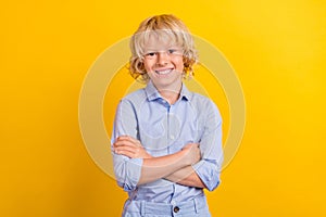 Photo of clever attractive school boy wear blue shirt smiling arms folded isolated yellow color background