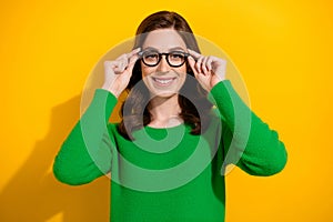 Photo of clever cheerful gorgeous girl toothy smile hands hold glasses isolated on yellow color background