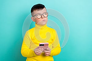 Photo of clever pensive boy using gadget plan writing blog post isolated on cyan blue color background