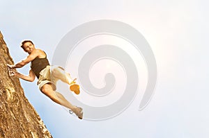 Portrait of Climber Jumping off Cliff with yellow lens flare