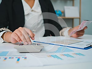 Photo close up hands of business woman working on desk office with using a calculator to calculate the numbers, Finance accounting