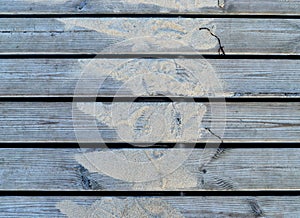 A photo of a close-up of old boards with sand