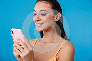 Photo closeup of alluring joyful woman using cellphone and smiling