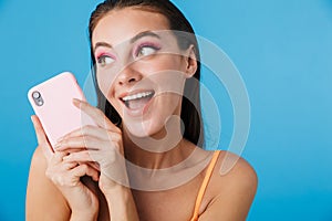 Photo closeup of brunette excited woman using cellphone and laughing