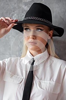 Photo closeup of business woman in black hat, casual white shirt, tie with professional makeup, gray background, free