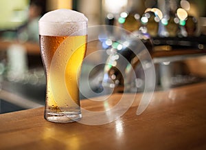 Photo of cold beer glass on a bar.