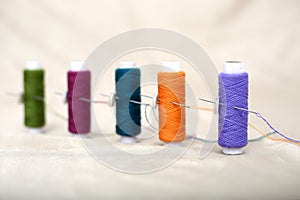 Photo of colored sewing thread and needle on the cloth