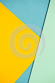 Photo of colored sheets of paper: yellow, orange, blue and green. Suitable for design templates, covers, banners