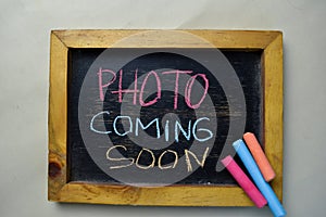 Photo Coming Soon write on a chalkboard isolated on wooden table