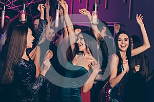 Photo of company celebrating prom at party in the night club dancing together laughing relaxing hands up wearing festive