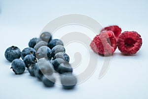 Composition of a pile of blueberries and raspberries with white background