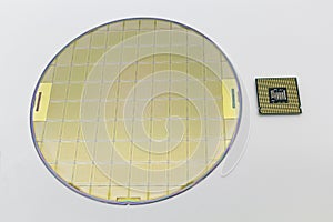 Photo of a Computer Chip CPU put near silicon wafer with microchip