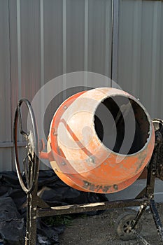 Photo concrete mixer installed on the construction site next to a pile of sand and gravel.