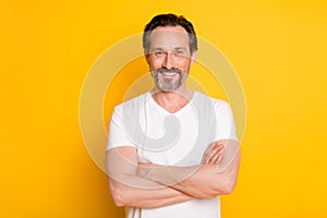 Photo of confident bearded man crossed arms toothy beaming smile wear white t-shirt isolated yellow background