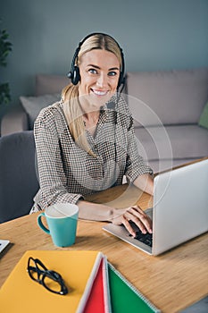 Photo of confident helpdesk representative use netbook app answer clients request problems sit desk in modern workspace