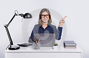 Photo of confident lady sit table direct finger empty space wear dotted blouse isolated grey color background photo