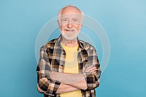 Photo of confident pretty man pensioner dressed checkered shirt arms crossed isolated blue color background