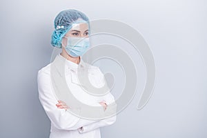 Photo of confident professional virologist doctor lady arms crossed look side empty space wear medical lab coat mask