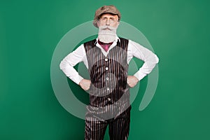 Photo of confident serious detective hands hips wear hat eyeglasses striped suit scarf on green color background