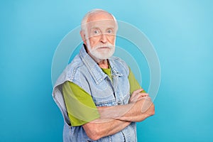 Photo of confident serious man pensioner dressed retro denim vest arms crossed isolated blue color background