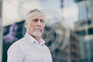 Photo of confident serious mature worker man wear formal shirt outdoors city street