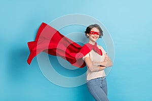 Photo of confident shiny lady dressed red mantle arms crossed cape flying isolated blue color background