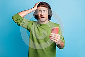 Photo of confused brunet hair guy hand on head stare stupor stylish pullover isolated on blue color background
