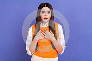 Photo of confused teenager school girl hands chest speechless bad news stupor unhappy scared reaction isolated on violet