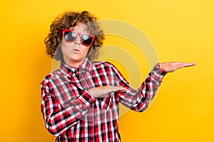 Photo of cool curly hairstyle teen boy dance wear eyewear red checkered shirt isolated on yellow color background