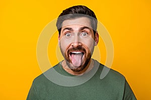 Photo of cool funky guy dressed green t-shirt showing two hard rock signs stick out isolated yellow color background