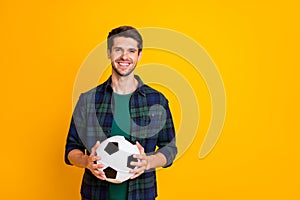 Photo of cool guy with white and black football ball excited to begin match wear casual plaid shirt isolated yellow