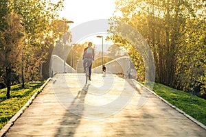 Dog running next to a woman riding a bike during sunset