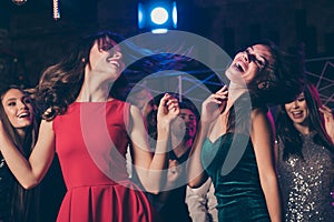 Photo of corporate party of cheerful pretty people wearing festive clothes dancing together on floor in night club