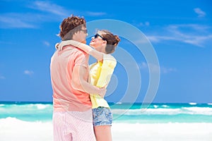 Photo of couple in bright clothes hugging on