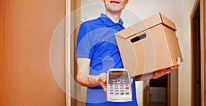 Photo of courier man with cardboard box in hands and with terminal photo