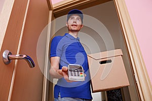 Photo of courier man with cardboard box in hands and with terminal photo