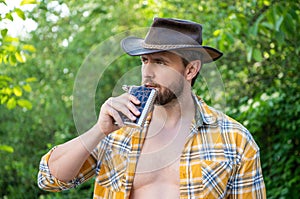 photo of cowboy man drink bourbon hipflask. cowboy man with bourbon hipflask.