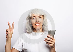 Photo of crazy ecstatic old woman use smartphone