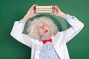 Photo of crazy funky funny mad crazy scientist shocked look up at book oh head isolated on green color background