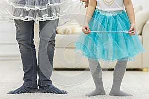 Photo of crop legs of father and daughter wearing funny clothes.