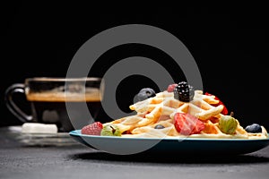 Photo of cup of coffee with Belgian wafers with strawberries, raspberries