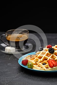 Photo of cup of coffee with Belgian wafers with strawberries, raspberries