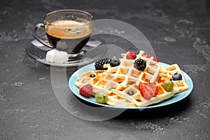 Photo of cup of coffee with Belgian wafers with strawberries, raspberries