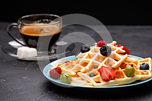 Photo of cup of coffee with Belgian wafers with strawberries, raspberries