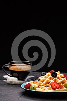 Photo of cup of coffee with Belgian wafers with strawberries, raspberries