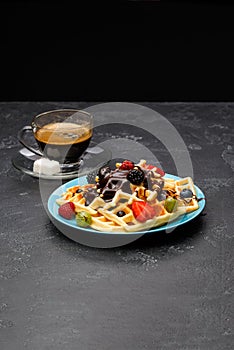 Photo of cup of coffee with Belgian wafers with strawberries, raspberries