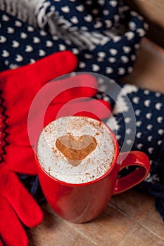 Photo of cup of coffee, scarf and gloves on thw wonderful brown