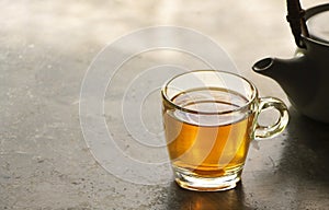 Photo of cup of hot ginger tea on a rustic concrete table