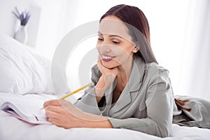 Photo of cute charming lady wear grey pajama enjoy weekend writing diary indoors house bedroom
