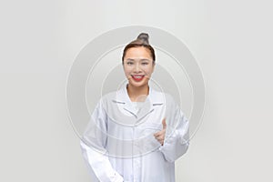 Photo of cute charming woman doc dressed white coat pointing thumb up